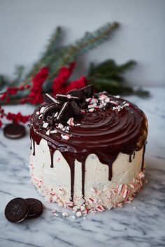 a chocolate cake with white frosting and sprinkles on a marble table