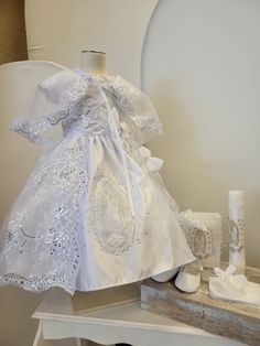 a white dress and shoes are sitting on a table