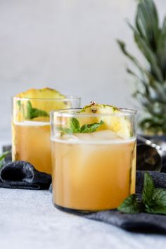 two glasses filled with pineapple smash on top of a table