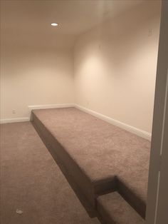 an empty room with carpeted flooring and no one is in the room or on the other side