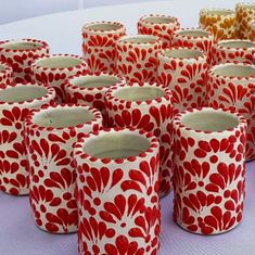 many red and white vases are lined up on a table