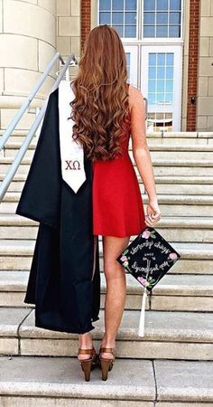 a woman in a graduation gown is walking down the stairs