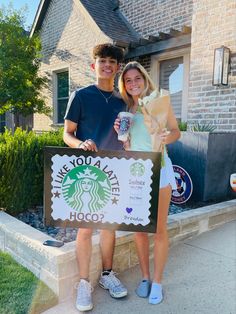 a man and woman holding a starbucks sign