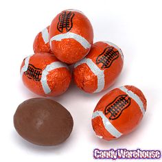 chocolate covered candies are piled on top of each other with an orange and white striped wrapper