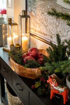 a wooden bowl filled with pomegranates sitting on top of a table