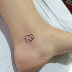 an elephant tattoo on the foot of a woman's left leg is shown in black ink