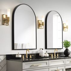 a bathroom with two sinks and mirrors on the wall next to each other in black and gold fixtures