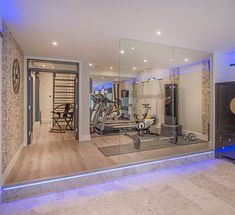 a home gym with mirrors and exercise equipment in the room that is lit up at night