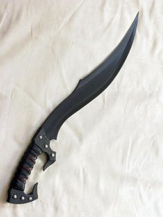 a knife that is laying on top of a white sheet with the blade still attached