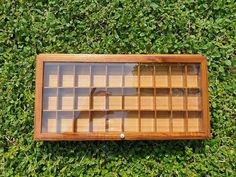 an overhead view of a wooden window in the middle of some green grass and bushes