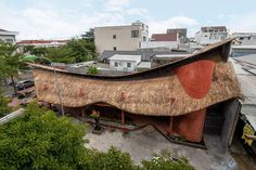 an aerial view of a building with thatched roof in the middle of a city