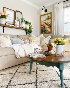 a living room filled with lots of furniture and flowers on top of a coffee table