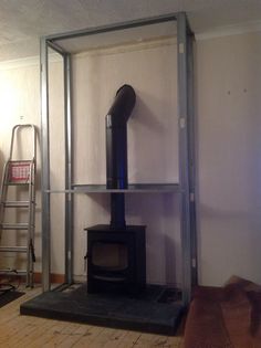 an old fashioned stove sitting in the corner of a room next to a ladder and wall