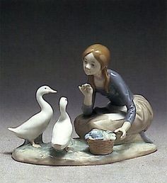 a figurine of a woman feeding ducks