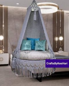 a white bed with blue pillows on top of it and a hanging hammock