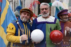 two men are holding soccer balls and posing for the camera