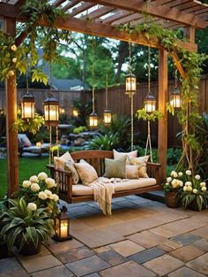 a wooden bench sitting under a pergoline covered arbor with hanging lanterns and flowers