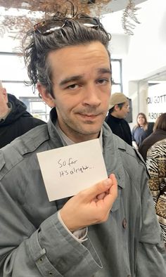 a man holding a piece of paper with writing on it