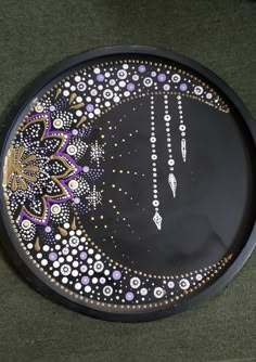 a black plate with purple and white designs on it