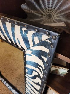 a zebra print mirror sitting on top of a wooden table