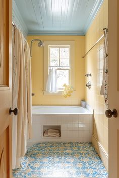 a bathroom with yellow walls and blue ceiling tiles on the floor, along with a white bathtub