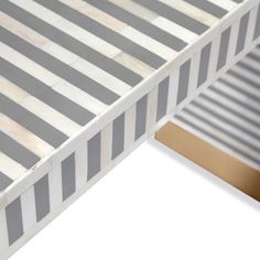 a close up view of a bed frame with stripes on the mattress and bottom half