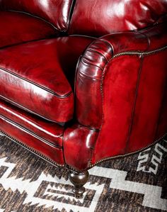 a red leather couch sitting on top of a rug