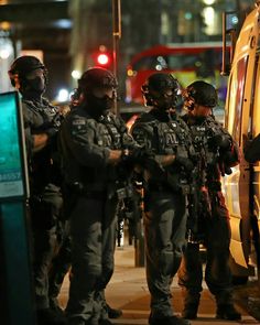 police officers standing in front of a bus at night