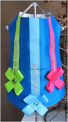 a blue, green and pink paper bag with bows hanging from it's side