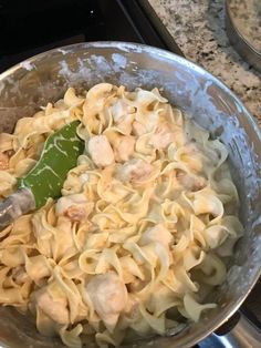 a pan filled with pasta and chicken on top of a stove