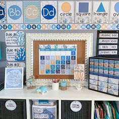 a white shelf topped with lots of crafting supplies next to a wall covered in pictures