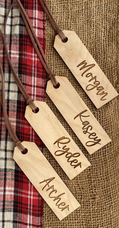 three wooden tags with the words merry christmas and happy new year hanging from leather cord