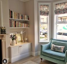 a living room filled with furniture and a fire place next to a window covered in books