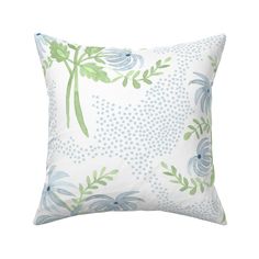 a white pillow with blue and green flowers on it