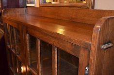 an antique wooden cabinet with glass doors