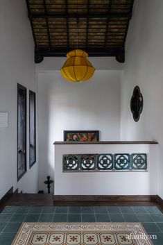 a room with tile flooring and a yellow light hanging from the ceiling above it