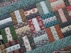 a close up of a patchwork quilt with many different colors and designs on it