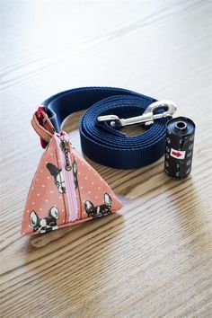 a dog leash with a pink and blue triangle on it next to a black camera