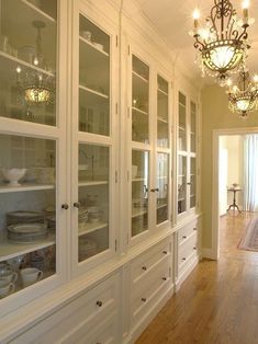 a white china cabinet with glass doors and lights on it's sides in a room