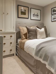 a bed sitting in a bedroom next to two framed pictures on the wall above it