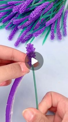 someone is making a purple flower out of paper