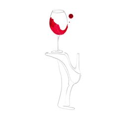 a wine glass sitting on top of a white table next to a red object in the shape of a hand