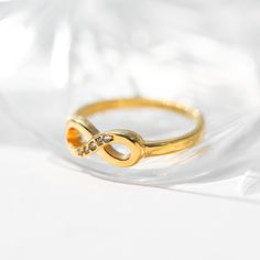 The Mimilux 18K Gold Infinity Ring is a beautiful symbol of everlasting love and connection. Crafted from high-quality stainless steel and plated with 18K gold, this dainty infinity ring is designed to be both elegant and durable. Its minimalist design makes it perfect for stacking with other rings or wearing solo as a delicate statement piece. Ideal for daily wear, the ring's sleek infinity motif is adorned with subtle cubic zirconia accents, adding just the right touch of sparkle. This ring is Gold Minimalist Infinity Midi Rings, Everyday Gold Infinity Ring, Infinity Ring Design, Minimalist Infinity Ring As Gift, Minimalist Yellow Gold Infinity Ring, Symbolic Infinity-shaped Gold Jewelry, Eternity Rings Stackable, Gold Infinity Ring, Infinity Design