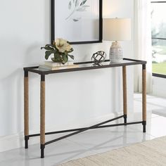 a console table with a vase and flowers on it