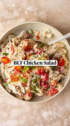 a white bowl filled with chicken salad on top of a table