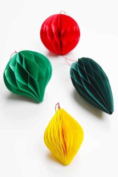 three different colored origami leaves on a white surface