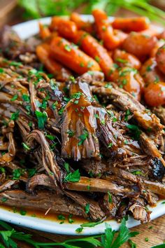 a white plate topped with meat and carrots