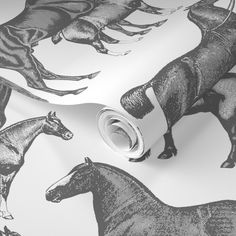 a wallpaper with horses on it and a roll of tape in the foreground