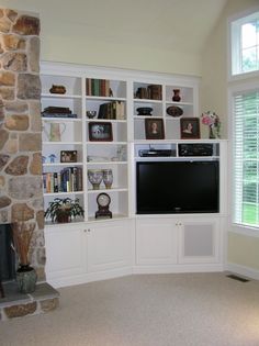 a living room filled with furniture and a flat screen tv mounted on a wall next to a fire place