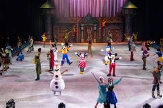 disney on ice characters and their families dancing in front of an audience at the show